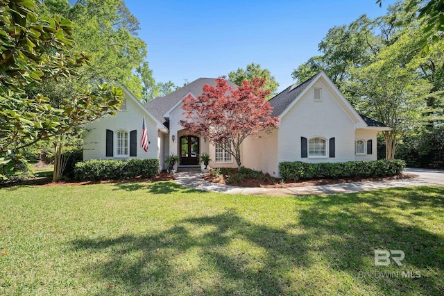 view of front of house with french doors, a front lawn, and brick siding