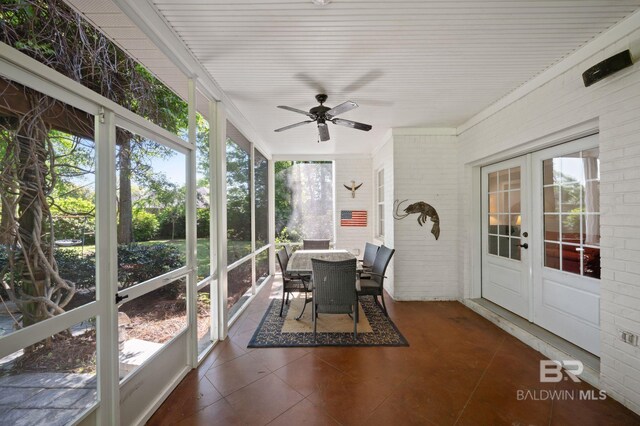 sunroom featuring outdoor dining space, french doors, and a ceiling fan