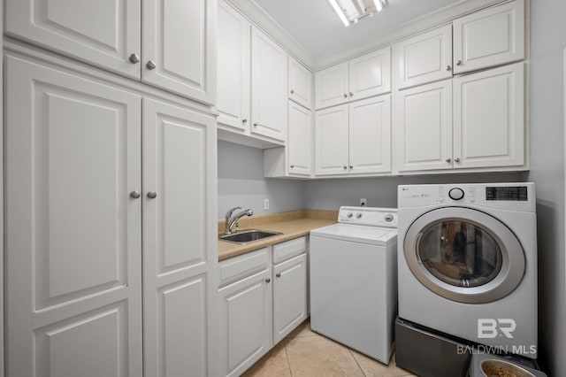 laundry area featuring light tile patterned flooring, independent washer and dryer, a sink, and cabinet space