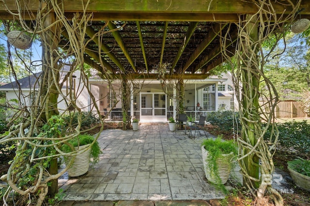 view of patio / terrace with a sunroom and a pergola