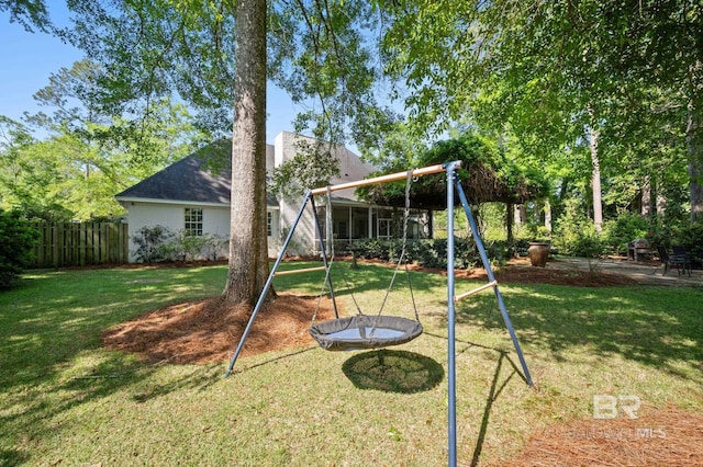 view of playground featuring fence and a lawn