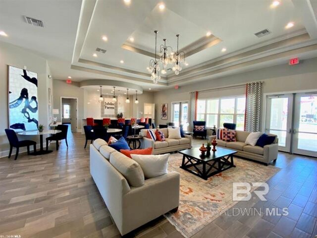 11006 Secretariat Blvd, Daphne, AL 36526 - living room featuring a raised ceiling, crown molding, recessed lighting, a chandelier, and wood finished floors