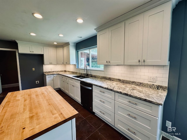 kitchen featuring backsplash, dishwasher, white cabinets, wooden counters, and sink