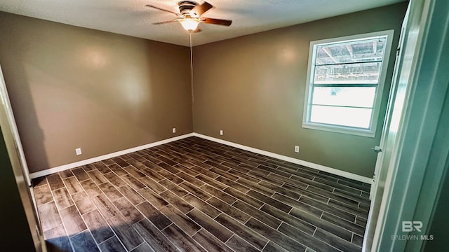 spare room with dark hardwood / wood-style flooring, ceiling fan, and a textured ceiling