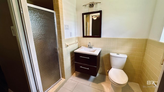 bathroom with tile walls, walk in shower, toilet, tile floors, and vanity