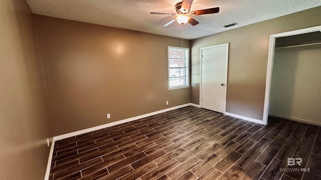 unfurnished bedroom with dark hardwood / wood-style flooring, ceiling fan, and a textured ceiling