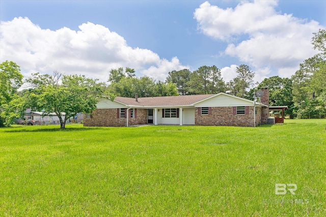 back of house with central AC unit and a lawn