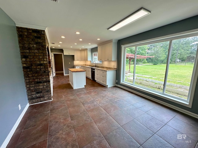 kitchen featuring backsplash, a wealth of natural light, and tile floors