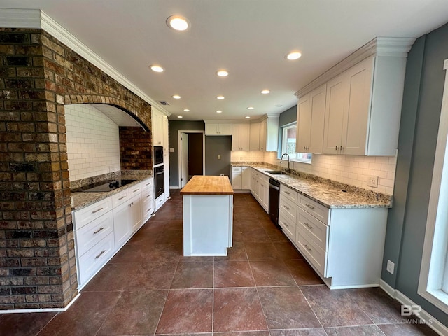 kitchen featuring a center island, tasteful backsplash, white cabinets, and sink