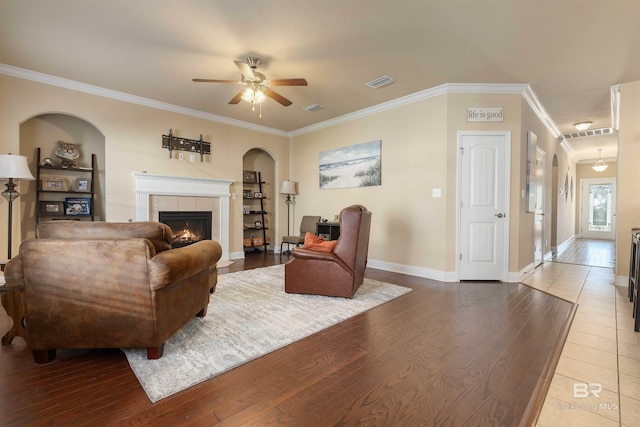 267 Galaxy St, Fairhope, AL 36532 - living room with visible vents, wood finished floors, crown molding, ceiling fan, and a tile fireplace