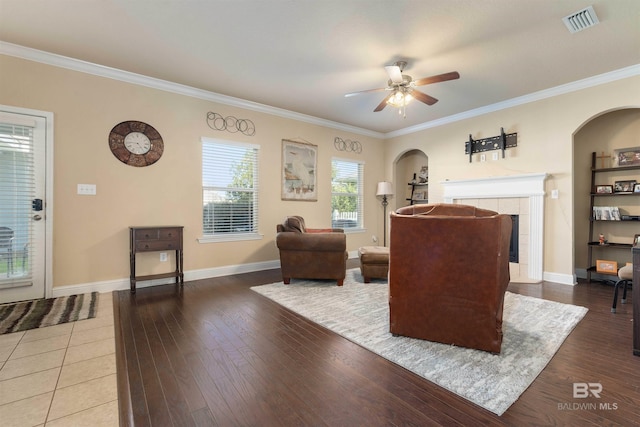 living room with ornamental molding, hardwood / wood-style flooring, and ceiling fan