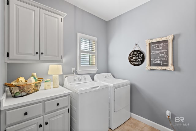 laundry area with washer and dryer, cabinets, and light tile patterned floors