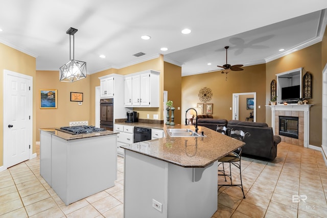 kitchen with black appliances, sink, hanging light fixtures, a kitchen breakfast bar, and white cabinets