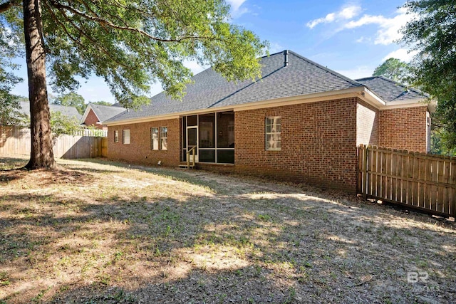 8814 N Dawes Lake Rd, Mobile, AL 36619 - back of house with a shingled roof, a sunroom, brick siding, and a fenced backyard
