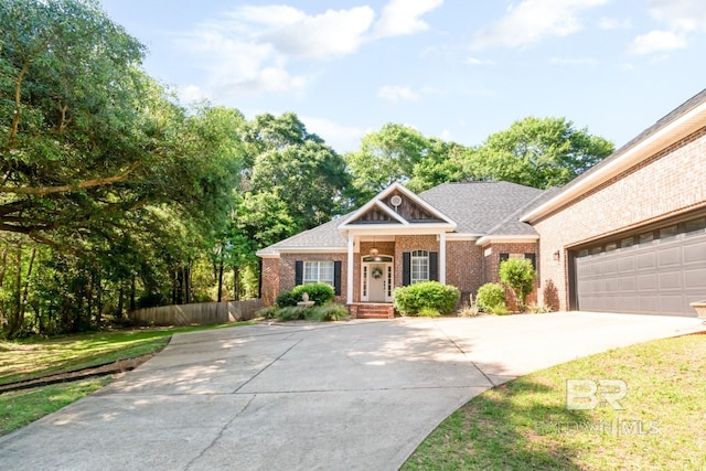 8814 N Dawes Lake Rd, Mobile, AL 36619 - craftsman inspired home featuring an attached garage, fence, concrete driveway, brick siding, and roof with shingles