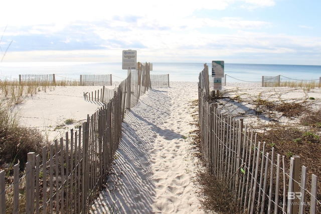 view of home's community with a water view and a beach view