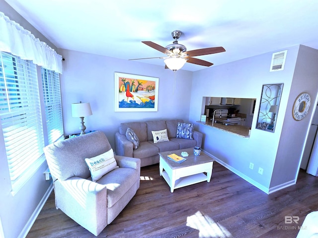 living room featuring ceiling fan, dark hardwood / wood-style floors, and sink