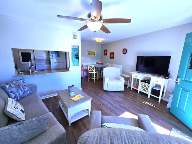 living room featuring dark hardwood / wood-style flooring, ceiling fan, and sink