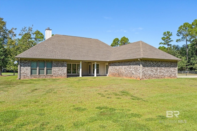 rear view of property featuring a yard