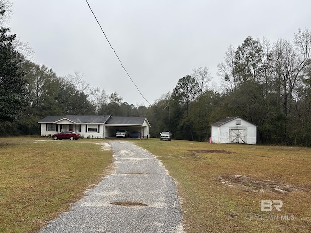 ranch-style house featuring a front yard and an outbuilding