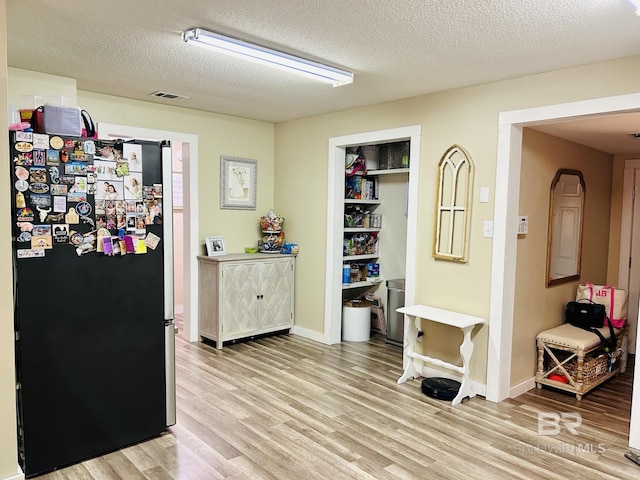 interior space featuring a textured ceiling and light hardwood / wood-style floors