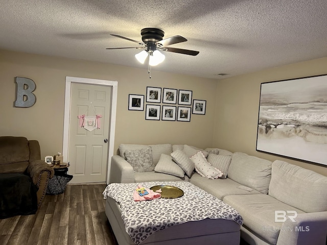 living room featuring dark hardwood / wood-style flooring, a textured ceiling, and ceiling fan