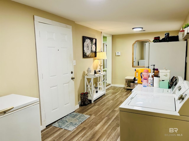 clothes washing area featuring light hardwood / wood-style flooring and independent washer and dryer