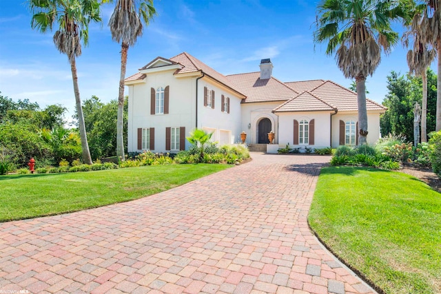 mediterranean / spanish-style house featuring a front lawn and a garage