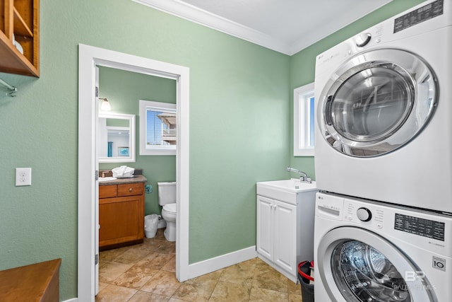 laundry room featuring stacked washer / dryer, crown molding, light tile patterned flooring, and sink