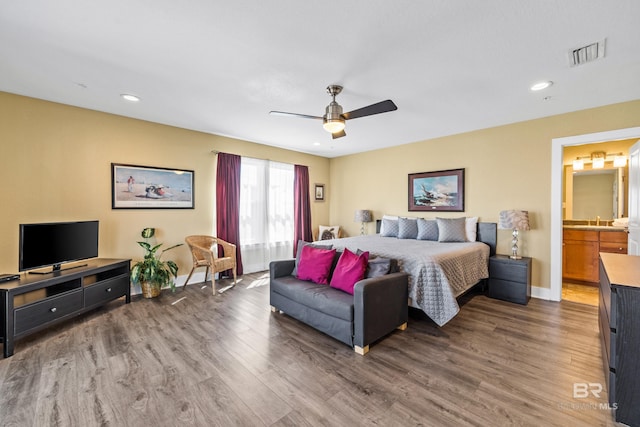 bedroom featuring ceiling fan, sink, connected bathroom, and dark hardwood / wood-style flooring