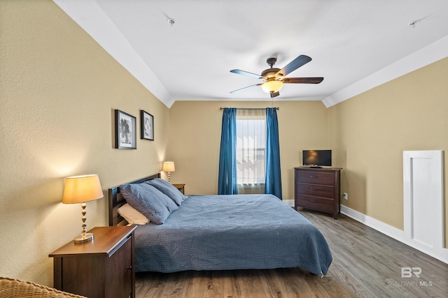 bedroom with crown molding, lofted ceiling, hardwood / wood-style floors, and ceiling fan