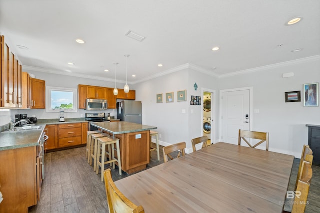 kitchen featuring a kitchen island, decorative light fixtures, stainless steel appliances, a breakfast bar area, and dark hardwood / wood-style flooring