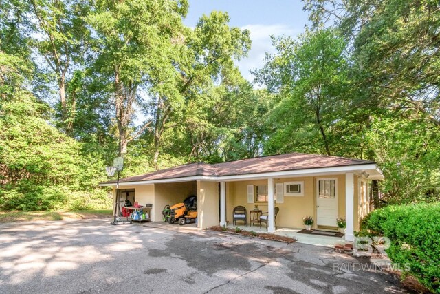 306 Thornton Pl, Mobile, AL 36609 - view of front of home featuring stucco siding, a carport, and covered porch