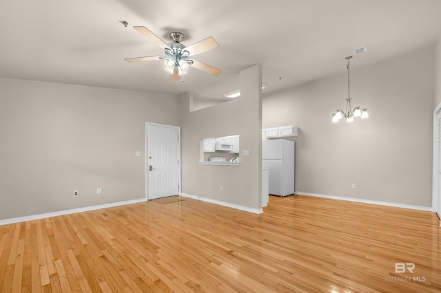 unfurnished living room with light wood finished floors, visible vents, baseboards, lofted ceiling, and ceiling fan with notable chandelier