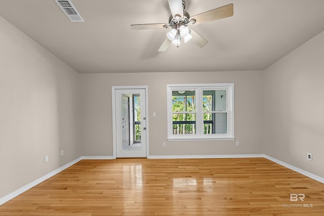 spare room with visible vents, ceiling fan, light wood-style flooring, and baseboards