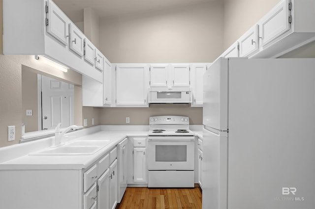 kitchen featuring light countertops, white appliances, a sink, and white cabinets