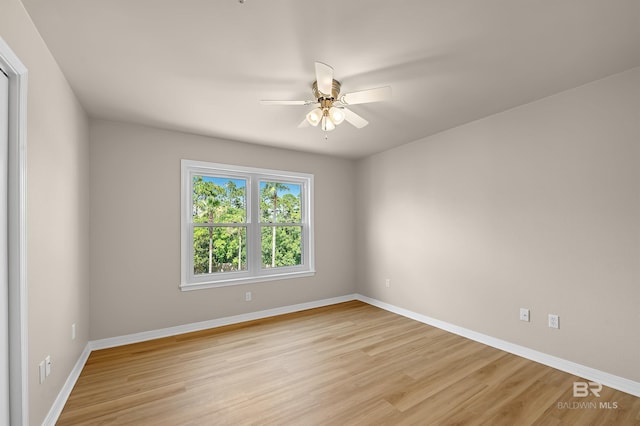 empty room featuring baseboards, ceiling fan, and light wood finished floors