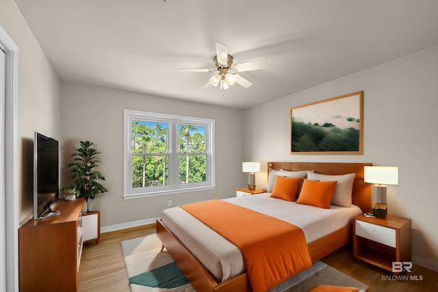 bedroom with light wood finished floors and baseboards