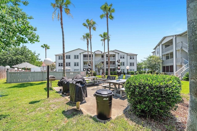 view of home's community featuring a lawn and fence