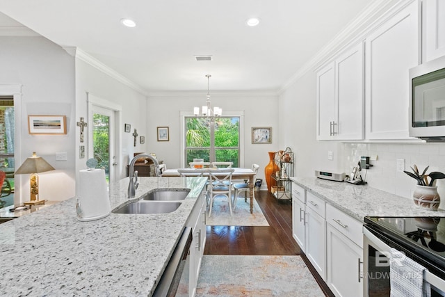 kitchen featuring light stone counters, stainless steel appliances, sink, pendant lighting, and white cabinets