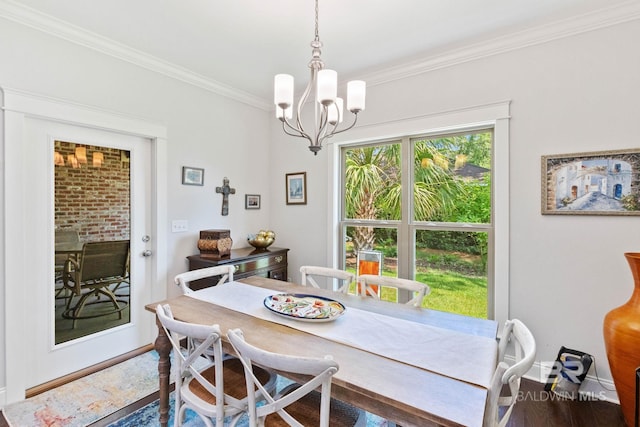 dining area featuring wood-type flooring, a notable chandelier, and ornamental molding