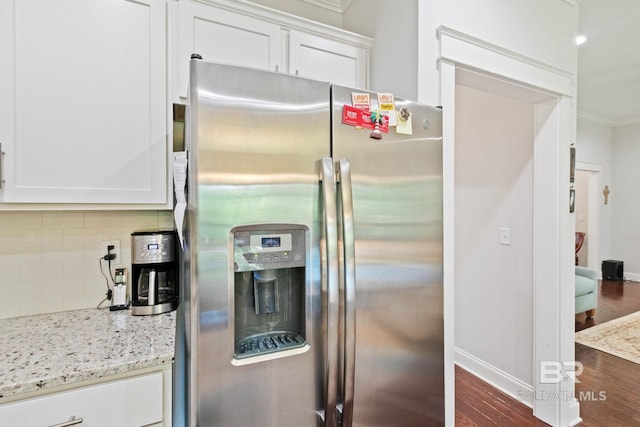 kitchen featuring stainless steel fridge with ice dispenser, dark hardwood / wood-style floors, tasteful backsplash, light stone counters, and white cabinetry