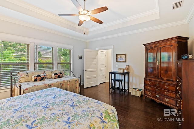 bedroom with ceiling fan, dark hardwood / wood-style floors, a raised ceiling, and ornamental molding