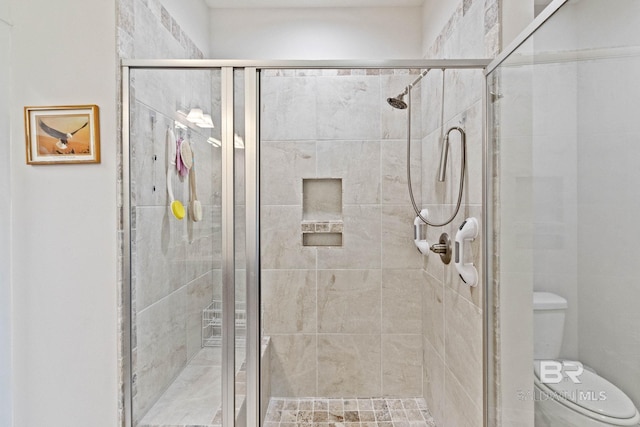 bathroom featuring toilet and an enclosed shower