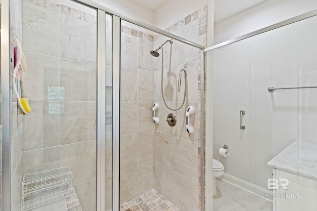 bathroom featuring toilet and a shower with shower door