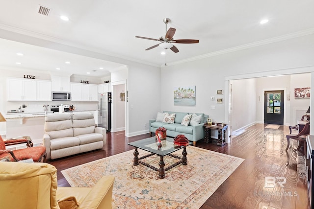 living room featuring ceiling fan, ornamental molding, and dark wood-type flooring