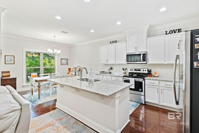 kitchen featuring sink, white cabinets, stainless steel appliances, and decorative light fixtures