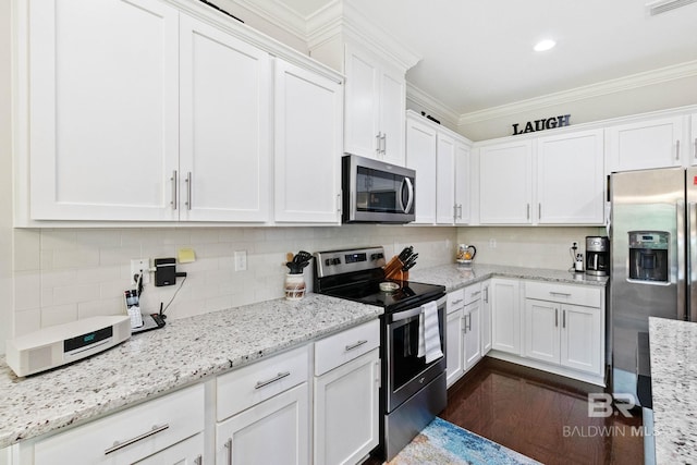 kitchen featuring tasteful backsplash, white cabinetry, stainless steel appliances, and ornamental molding