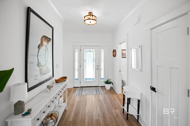 entryway with light wood-type flooring and ornamental molding