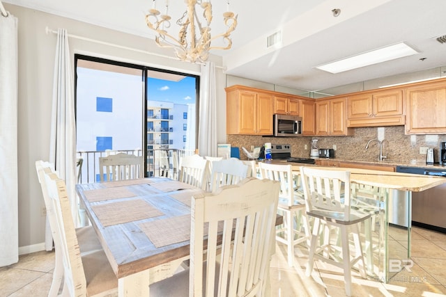 dining room featuring sink, an inviting chandelier, and light tile patterned flooring
